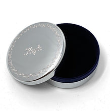 Silver round jewelry box with decorative border and engraved name